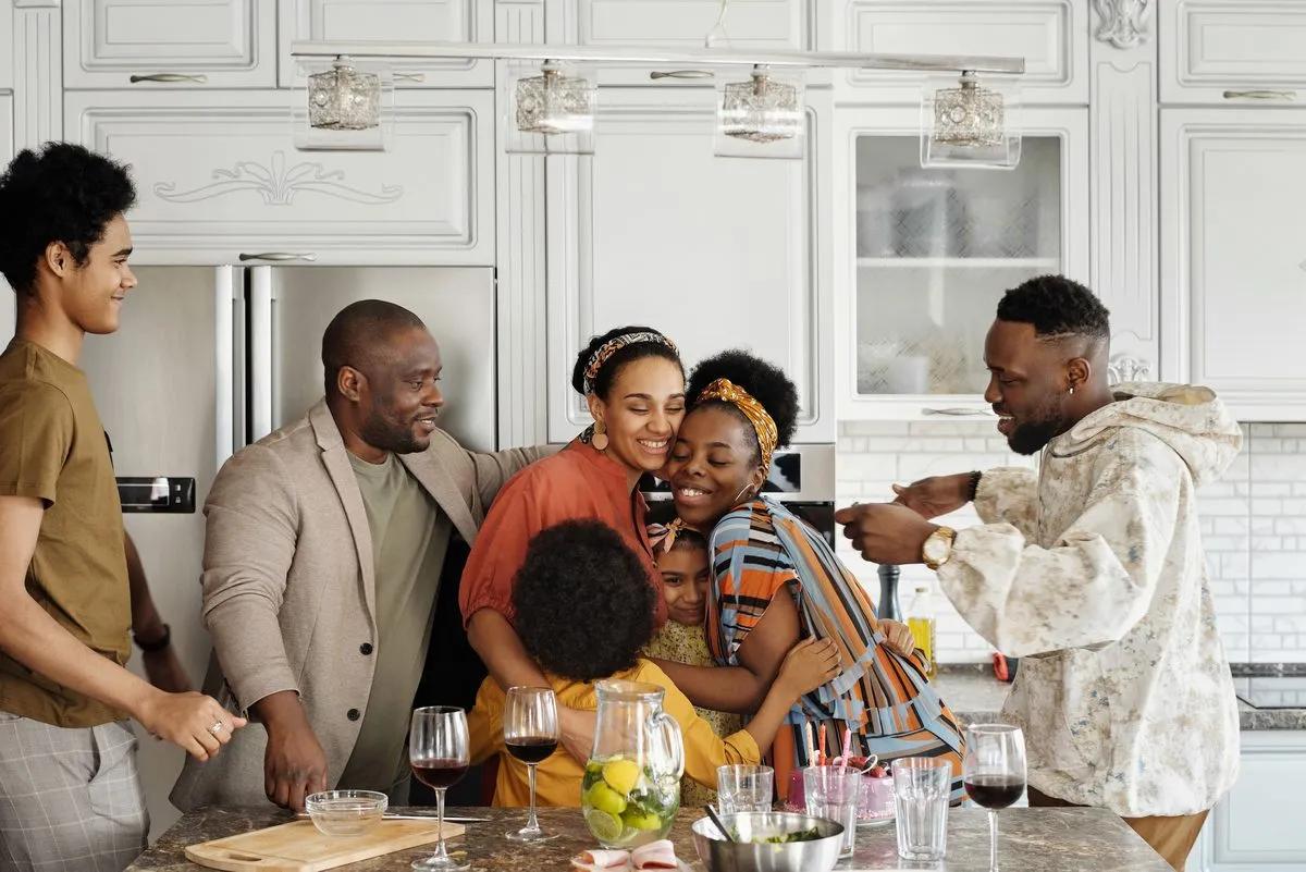 Three generations of a family cooking together in a bright kitchen